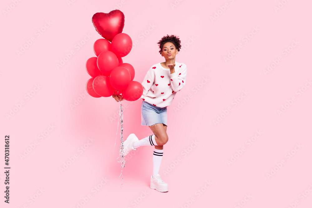 Full size photo of youth african lady send air kiss coquettish many helium balls isolated over pink color background Full size photo of youth african lady send air kiss coquettish many helium balls isolated over pink color background