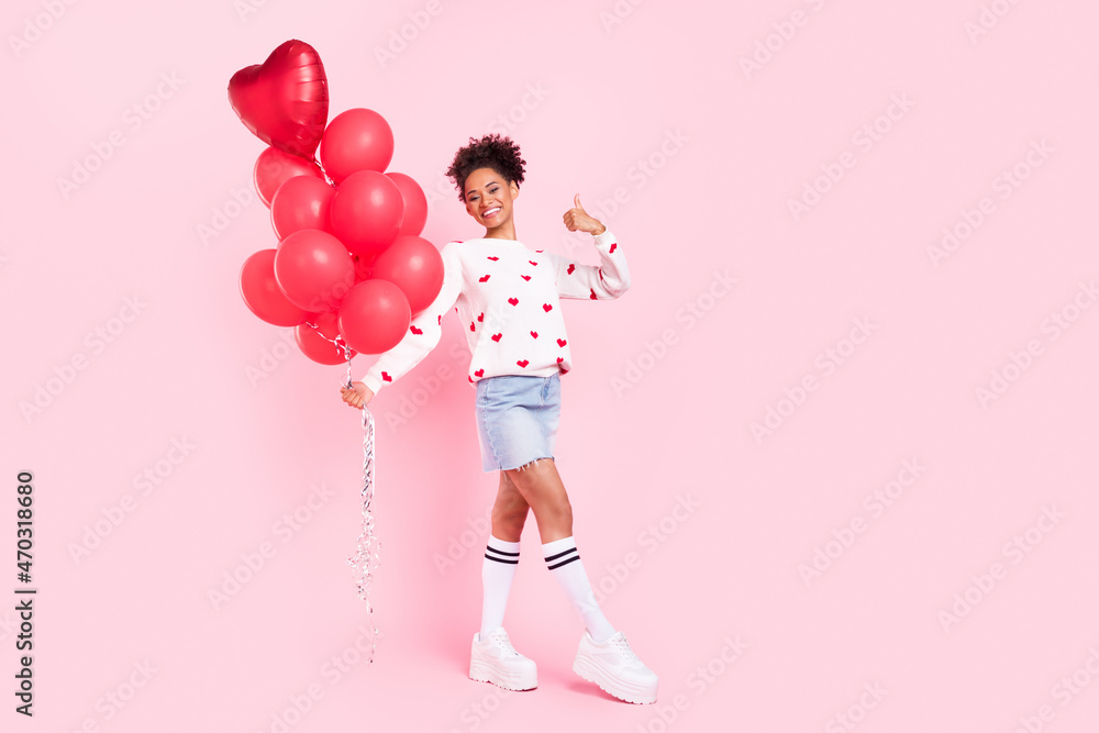 Full size photo of youth african girl hold many balloons decor show thumb-up advise suggest isolated over pink color background Full size photo of youth african girl hold many balloons decor show thumb-up advise suggest isolated over pink color background