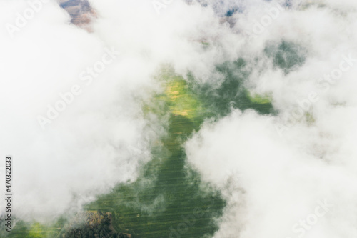 Landscape view from drone, green fields, sky with white clouds.