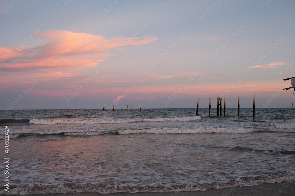 Wooden pilings left behind after a wooden pier collapsed in hurricane force wind and waves at sunset on the South Carolina Coast