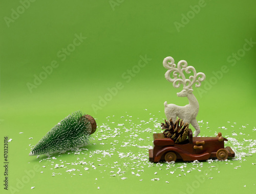 White deer on a green background. Creative concept of bringing a Christmas tree.