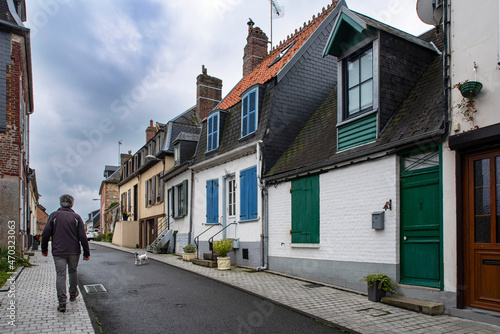 Village street with a tourist, a dog and old houses in the town of Saint Valéry-sur-Somme in France