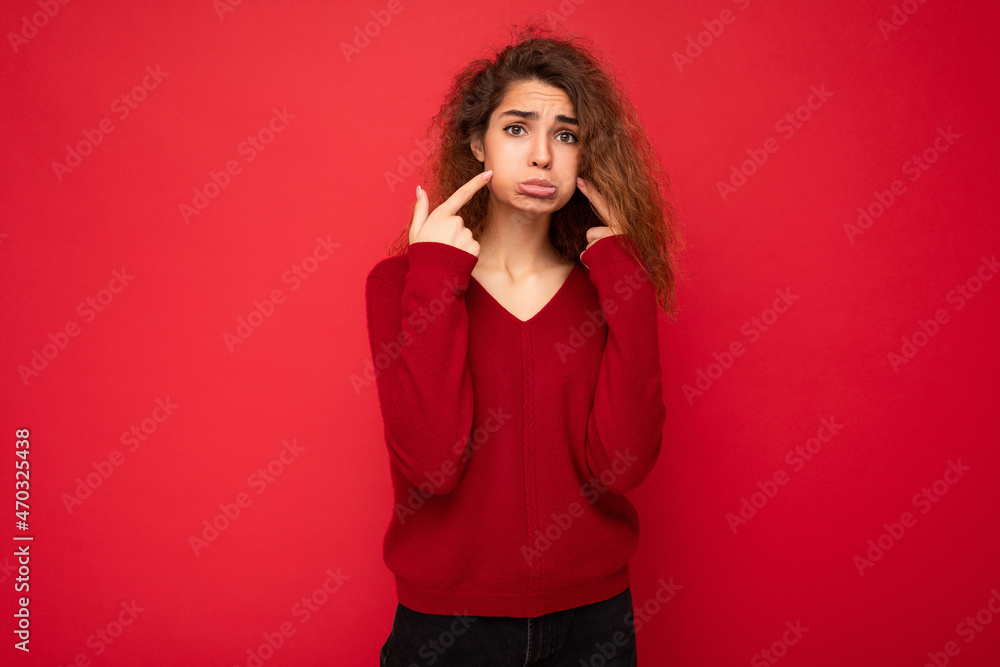 Photo of young offended touchy sad attractive brunette curly woman with sincere emotions wearing casual red pullover isolated on red background with copy space Photo of young offended touchy sad attractive brunette curly woman with sincere emotions wearing casual red pullover isolated on red background with copy space