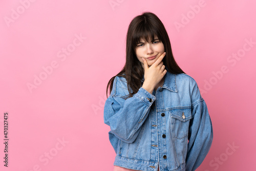 Young Ukrainian woman isolated on pink background having doubts © luismolinero