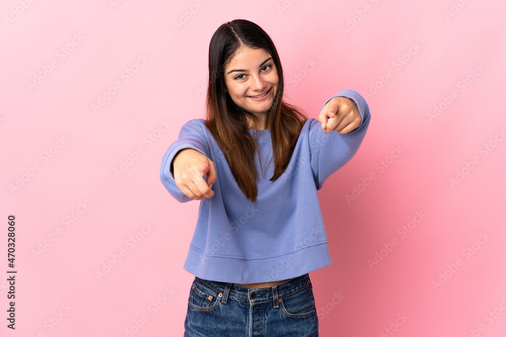 Young caucasian woman isolated on pink background pointing front with happy expression Young caucasian woman isolated on pink background pointing front with happy expression