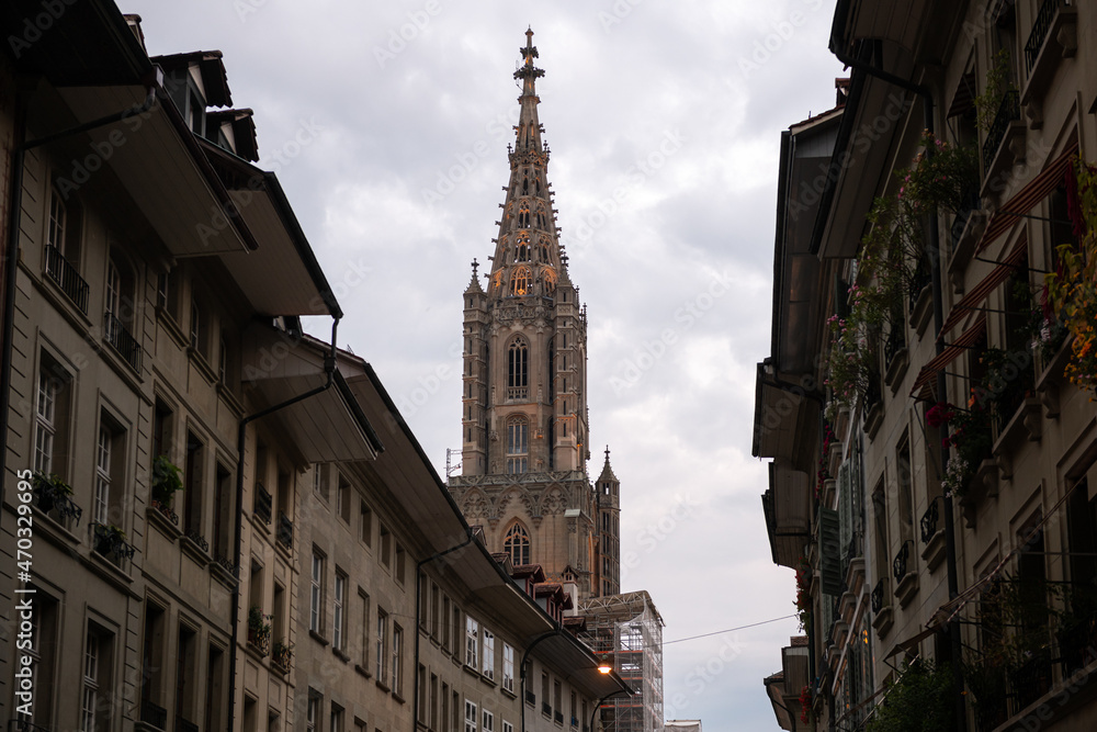 Travel to Switzerland. Berner Münster cathedral with amazing architecture tower photographed during a cloudy morning. Landmark of this city from Bern.