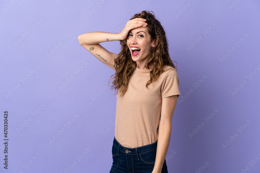 Young caucasian woman isolated on purple background doing surprise gesture while looking to the side Young caucasian woman isolated on purple background doing surprise gesture while looking to the side