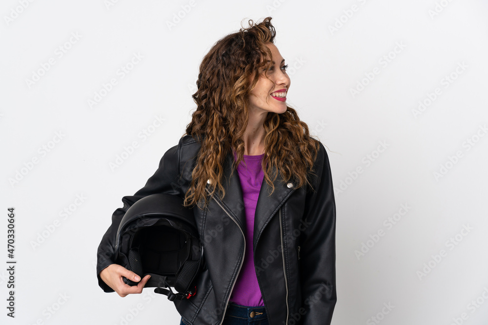 Young caucasian woman holding a motorcycle helmet looking side Young caucasian woman holding a motorcycle helmet looking side