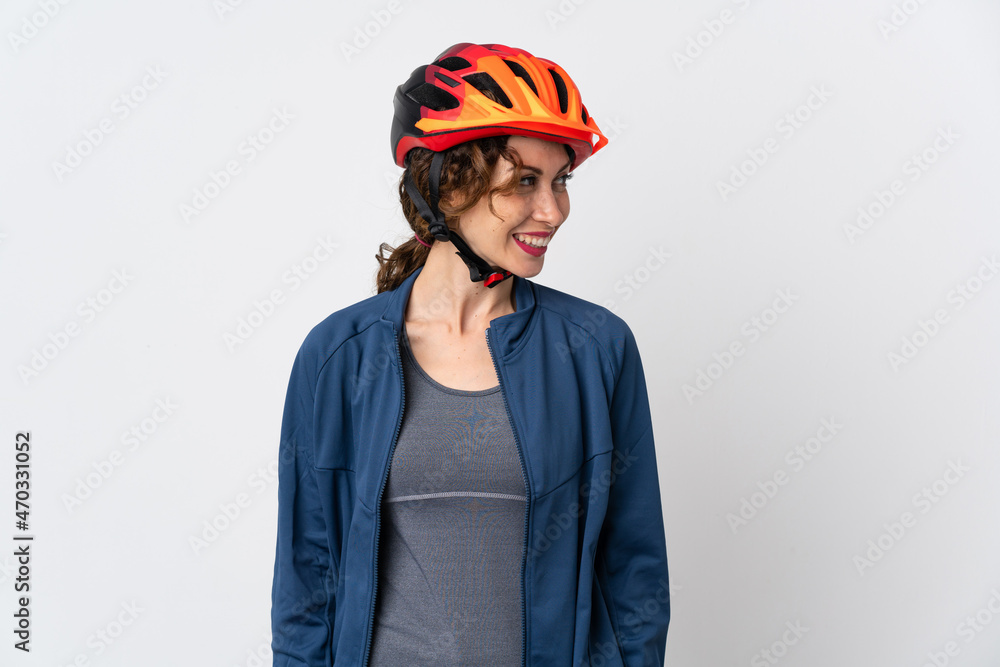 Fototapeta premium Young cyclist woman isolated on white background looking to the side and smiling