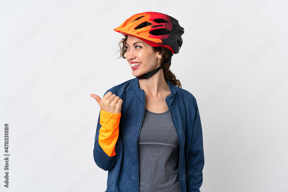 Young cyclist woman isolated on white background pointing to the side to present a product Young cyclist woman isolated on white background pointing to the side to present a product