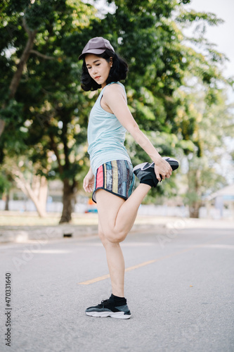 A beautiful woman stretching her body before running in the morning with a bright smile on her face. women's health care concept