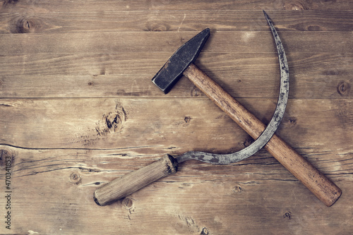 Sickle and hammer on wooden surface photo