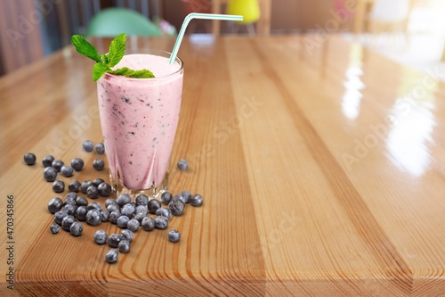 Tasty milkshake with blueberries in a glass on background. Healthy dessert