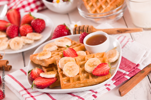 Waffles with strawberries, bananas and honey.