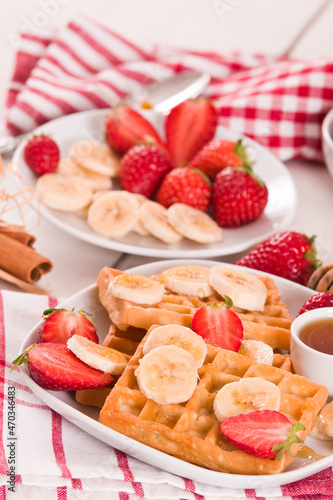 Waffles with strawberries, bananas and honey.