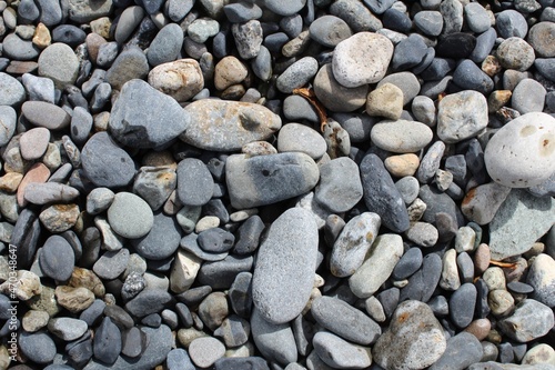 Pebble rocks on lake shore.