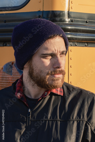 Young stylish hipster man looking across the street as he exits a bus