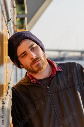 Young stylish hipster man leaning his head on an old yellow bus