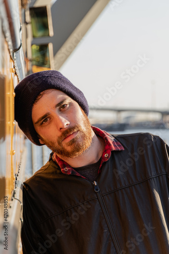 Young stylish hipster man staring with his head resting on an old yellow bus