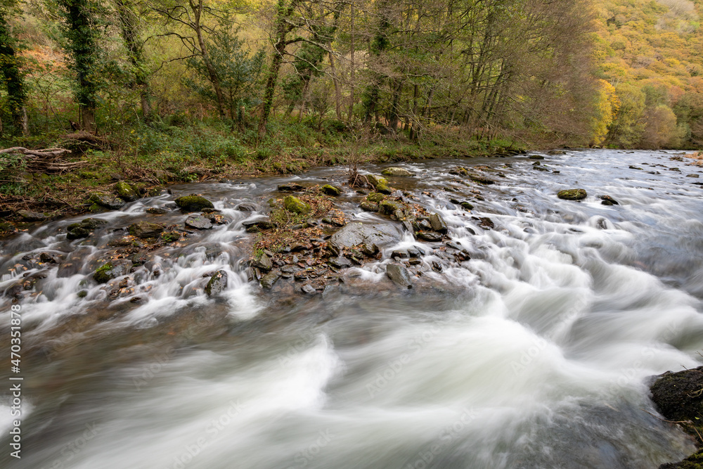 Long exposure of the East Lyn river flowing through the forest Watersmeet in Exmoor National Park