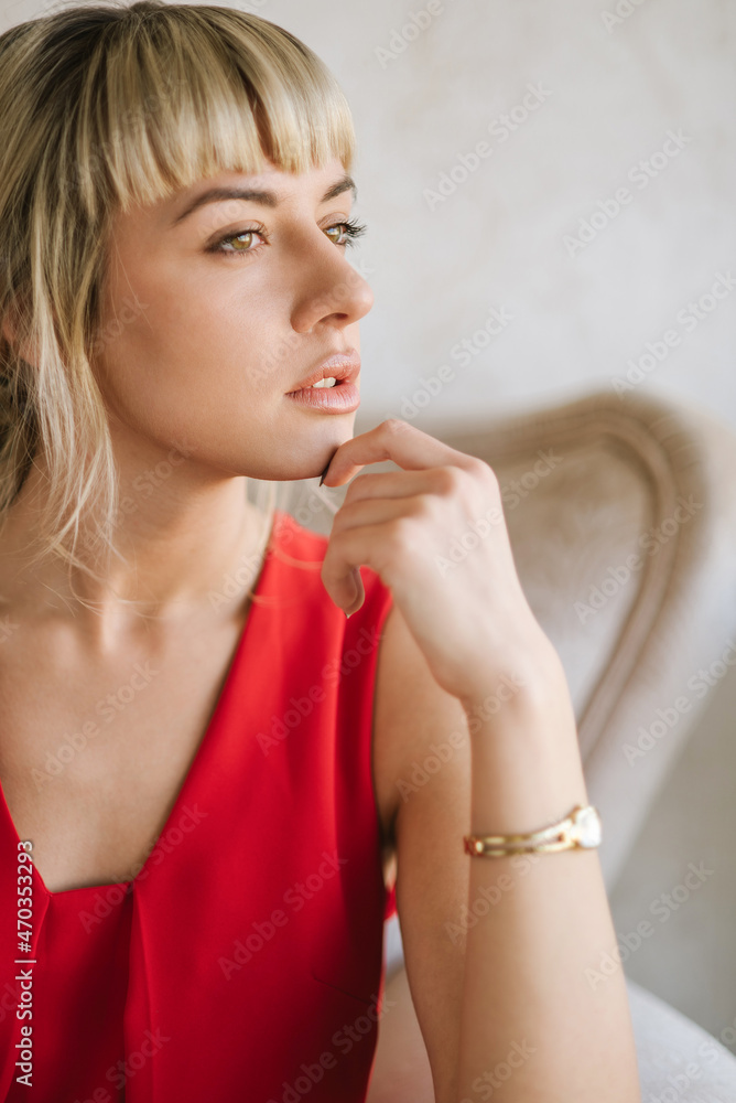 Portrait of beautiful blond young woman wearing red dress Portrait of beautiful blond young woman wearing red dress