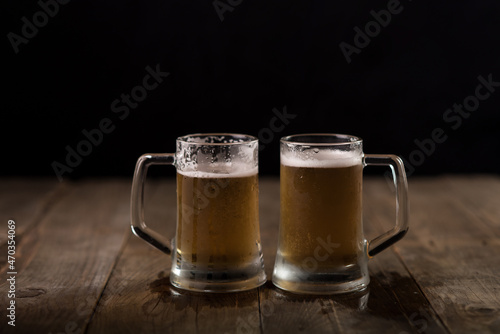 Two beer mugs at a wooden table