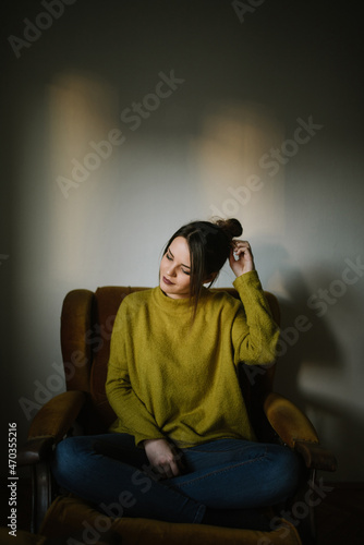 Portrait of a young woman sitting in armchair
