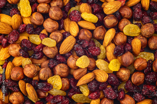 Mixed dried fruits background. Healthy snacks. Almonds, raisins, hazelnuts, cranberries. Assorted nuts and dried berries. View from above. Stack. Healthy food concept