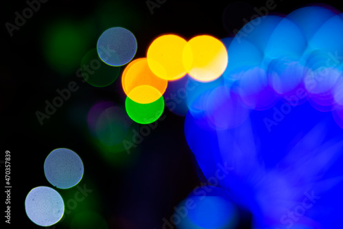 Colored blurred bokeh. abstract background of included festive garlands. colorful blur light bulbs