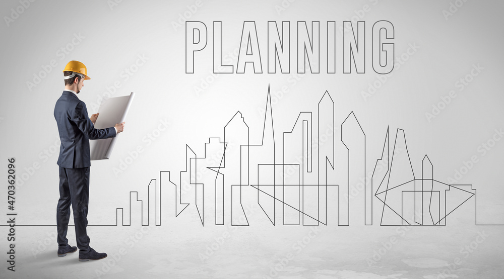 Businessman in hard hat holding blueprint Businessman in hard hat holding blueprint