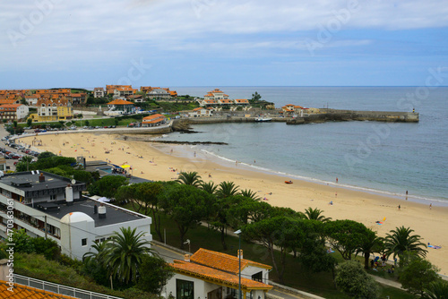 Landscape from viewpoint Santa Lucia in Comillas, Cantabria, Spain. Sight of the beach, breakwater, gardens and houses near the sea. photo