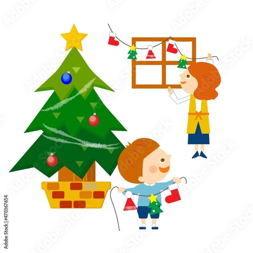 クリスマスツリーと飾り付けをする親子