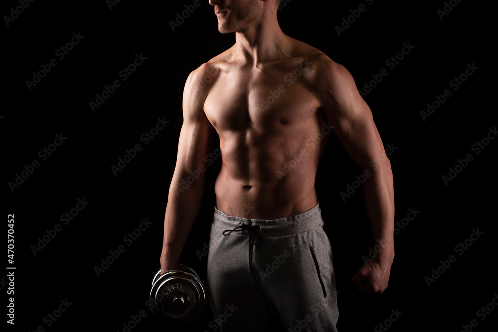 Man Showing ABS. Muscle man Posing with Dumbbell in Hand. Strong Body Concept. Topless Sport man Bodybuilder. Six Pack Spotsman