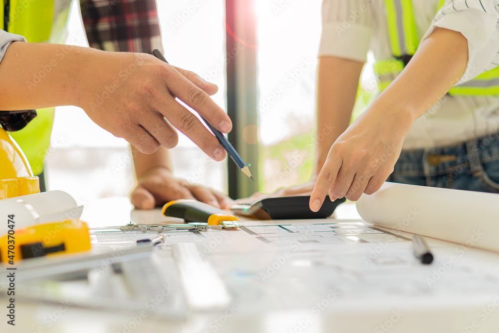 Obraz premium Engineers and architects are helping to design blueprints and jointly analyze the structure of the project type of the engineering team meeting and planning the construction. ideas for teamwork