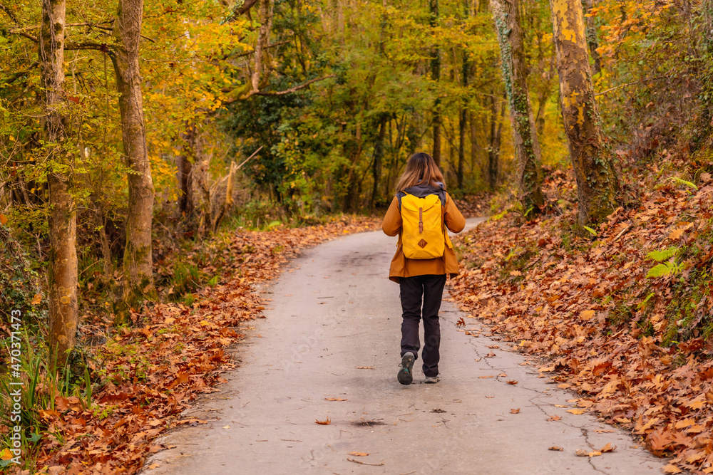 A young woman on a path to Mount Erlaitz in autumn in the town of Irun, Gipuzkoa. Basque Country