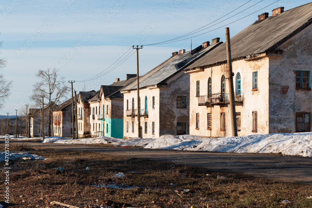 dilapidated two-story houses along the road in winter