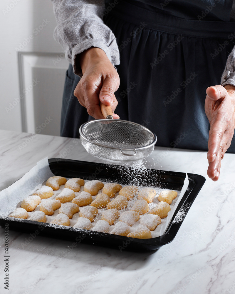 Coating vanillekipferl Cookie with Sugar Dust Using Strainer, Fresh Home Baked Christmas Cookies