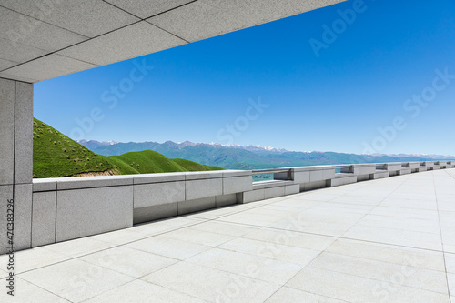 Empty square floor and mountains under blue sky