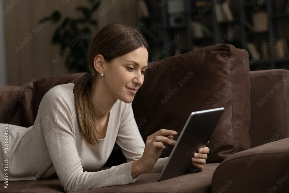 Happy woman relax on sofa with digital tablet, spend carefree weekend use modern tech, buying tickets, booking hotels via internet services, chat in social media, enjoy comfort remote shopping concept Happy woman relax on sofa with digital tablet, spend carefree weekend use modern tech, buying tickets, booking hotels via internet services, chat in social media, enjoy comfort remote shopping concept