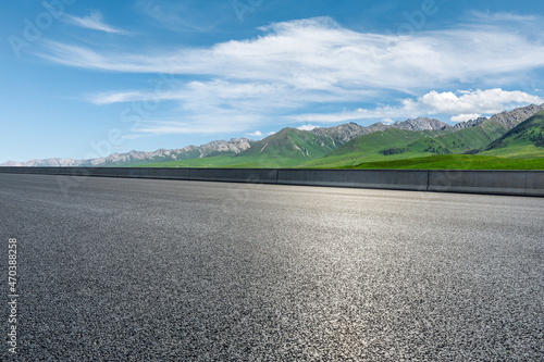 Asphalt highway and mountain under blue sky.Empty road and mountain nature background. © ABCDstock