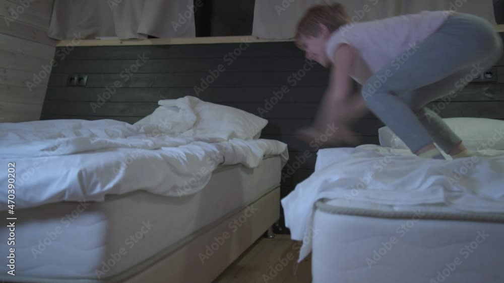 Crazy child jumping from bed to bed. The child is dancing and having fun