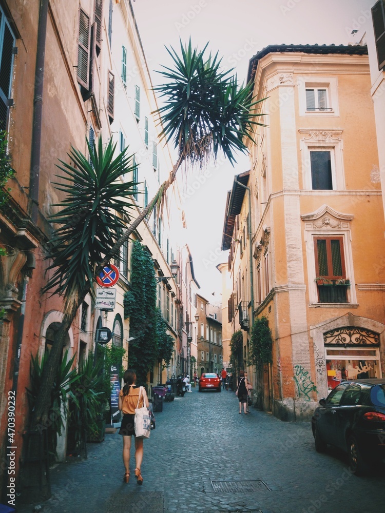Fototapeta premium woman walking down an alley in rome