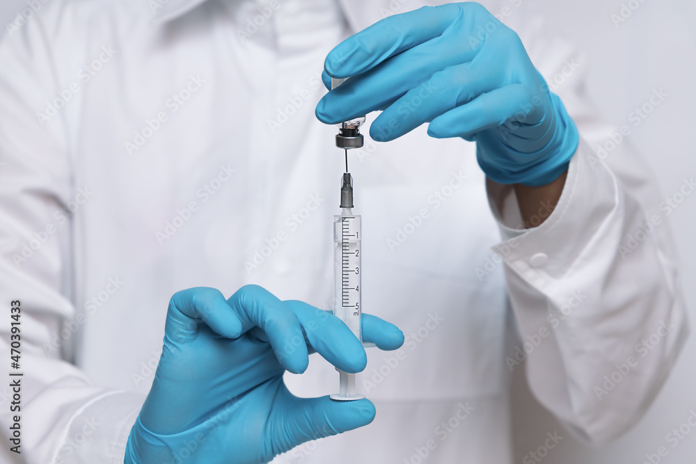 The medical professional prepares the syringe with the cure for vaccination The medical professional prepares the syringe with the cure for vaccination