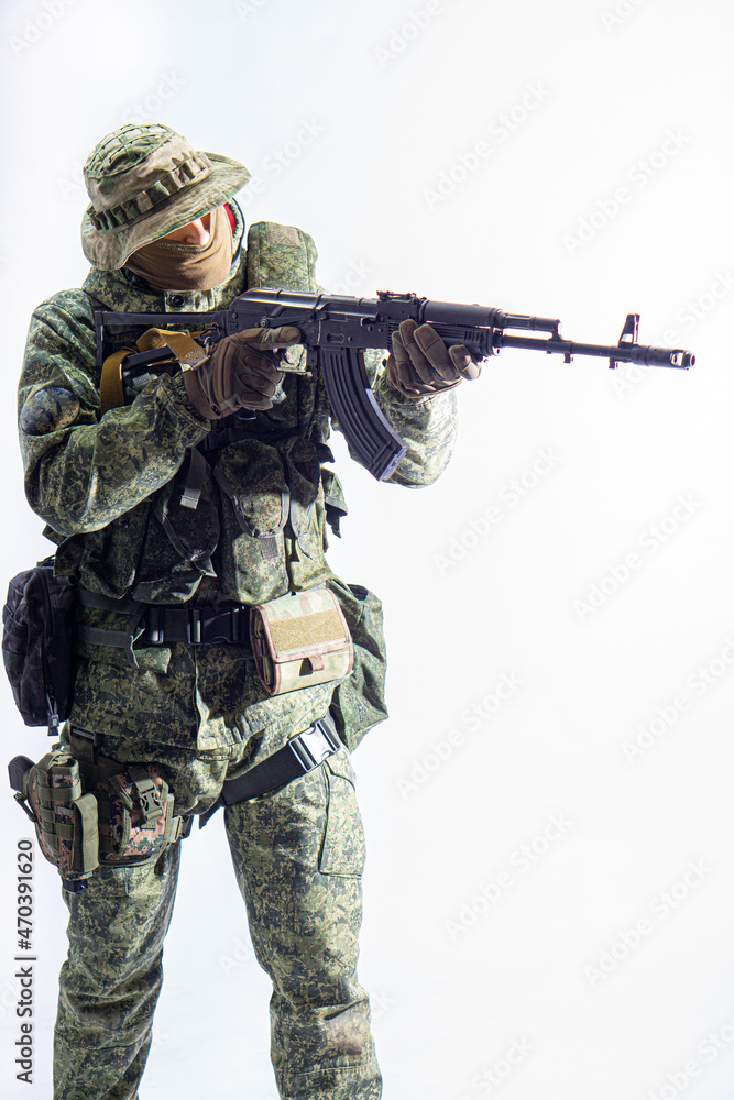Members of the special purpose unit. A Russian special forces soldier with assault rifle aiming from a machine gun on a white background Members of the special purpose unit. A Russian special forces soldier with assault rifle aiming from a machine gun on a white background
