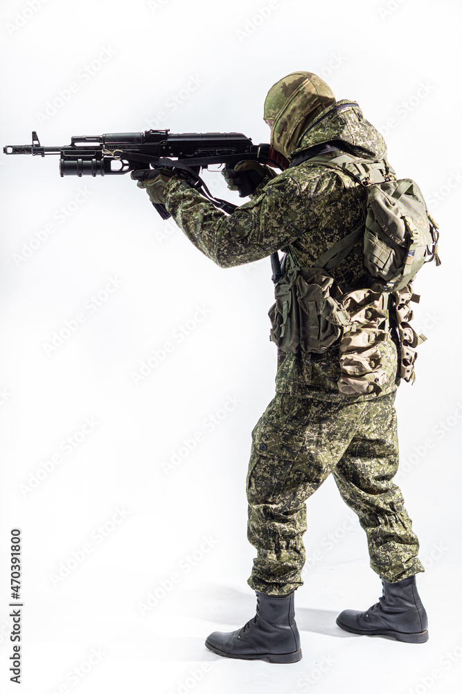 Members of the special purpose unit. A Russian special forces soldier with assault rifle aiming from a machine gun on a white background Members of the special purpose unit. A Russian special forces soldier with assault rifle aiming from a machine gun on a white background