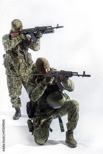 Members of the special purpose unit. Two Russian special forces soldiers with AK assault rifles in camouflage. Portrait on a white background.