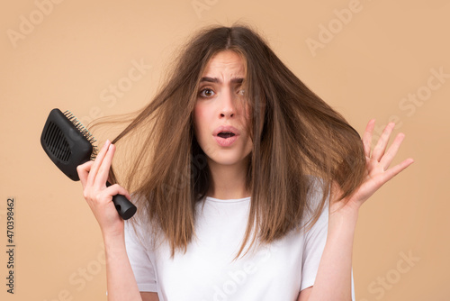 Hair loss problem treatment. Portrait of woman with a comb and problem hair. photo