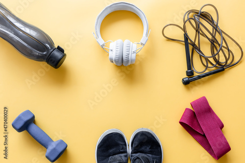 Flat lay composition with sports equipment on yellow background.