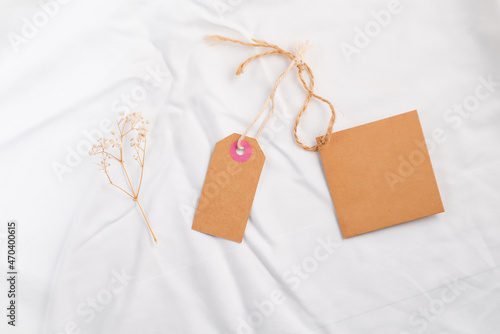 Mockup hanging gift tags eco-friendly kraft paper with dry flower on silk