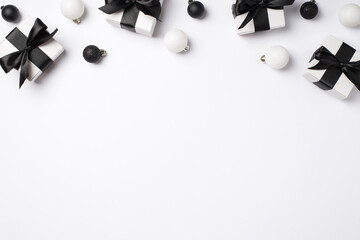 Top view photo of white gift boxes with black satin ribbon bows white and black christmas tree balls on isolated white background with empty space